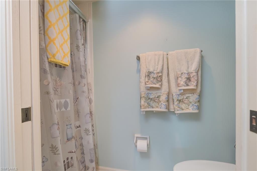 4121 Lorene Drive, Unit 207 Estero, FL 33928 - Photo 16 of 34 a bathroom with a toilet sink and shower curtain