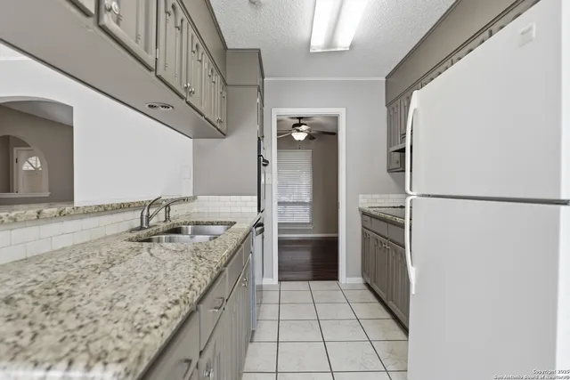 a kitchen with stainless steel appliances granite countertop a sink and a refrigerator