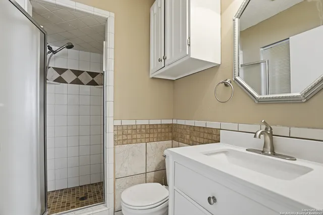 a bathroom with a sink a toilet and shower