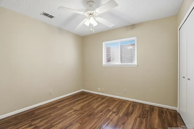 an empty room with a window and wooden floor