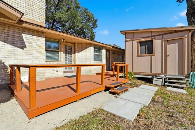 a backyard of a house with barbeque oven table and chairs