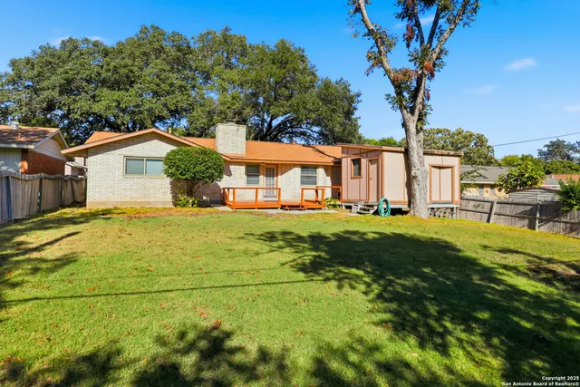 a yellow house with trees in front of it