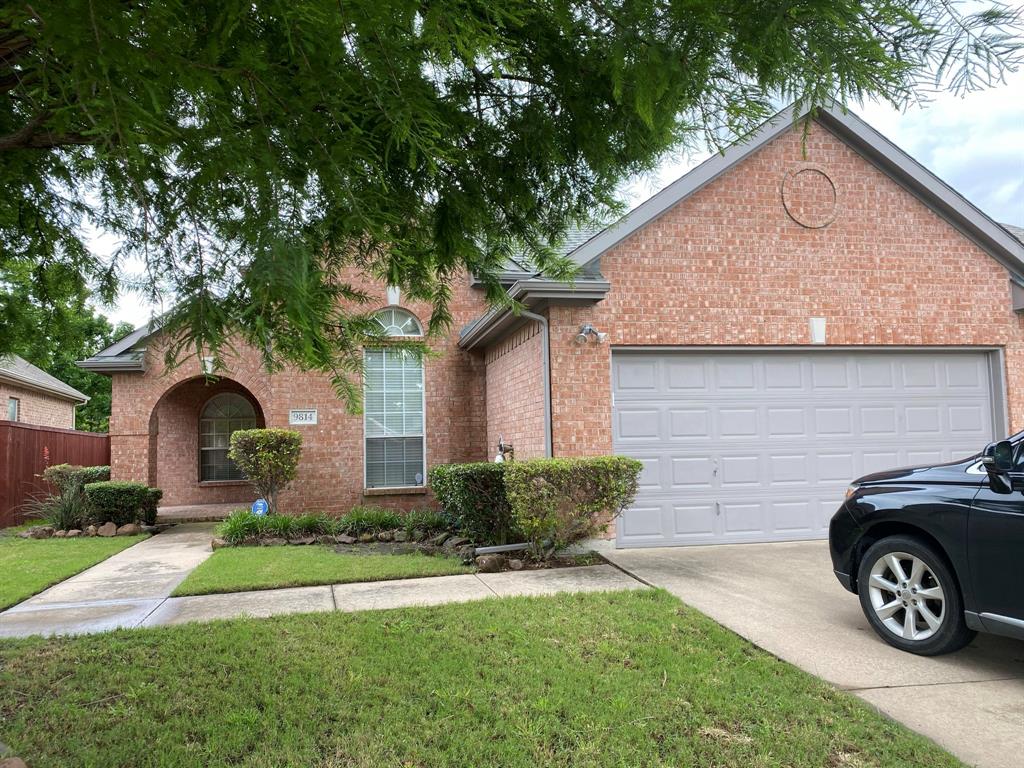 View of front facade featuring brick siding, driveway, and an attached garage