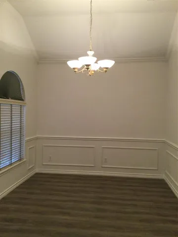 a view of a room with wooden floor and white walls