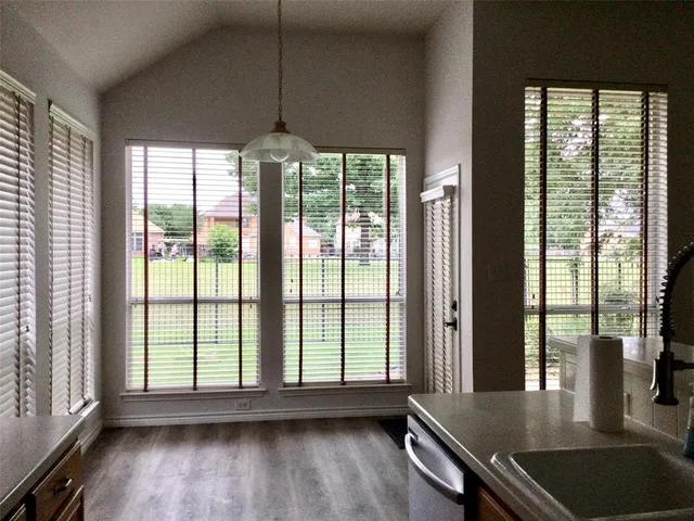 a view of a room with wooden floor and a floor to ceiling window