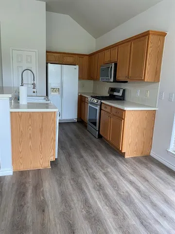 a kitchen with stainless steel appliances granite countertop a stove a sink and a refrigerator