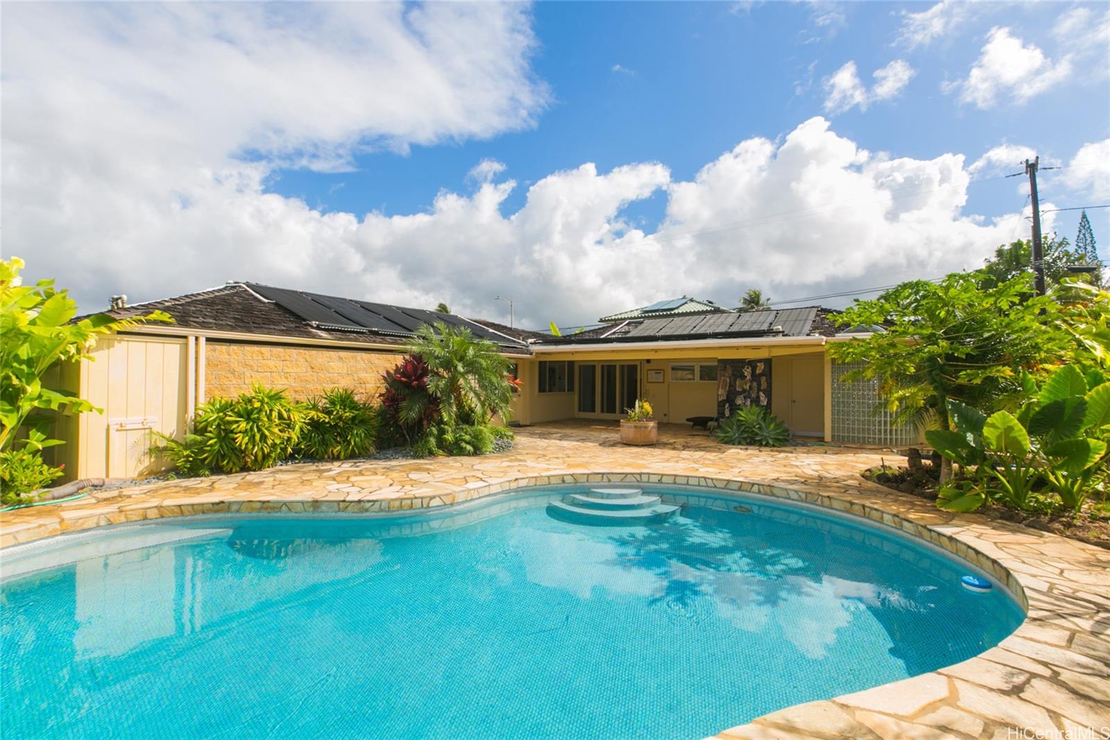 a front view of house with yard and trees in the background