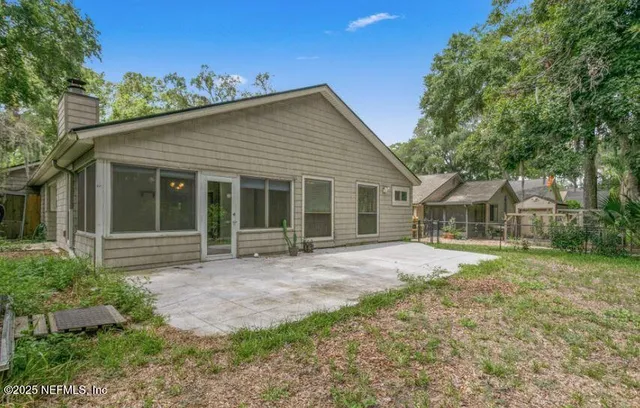a view of a yard in front of a house with large windows