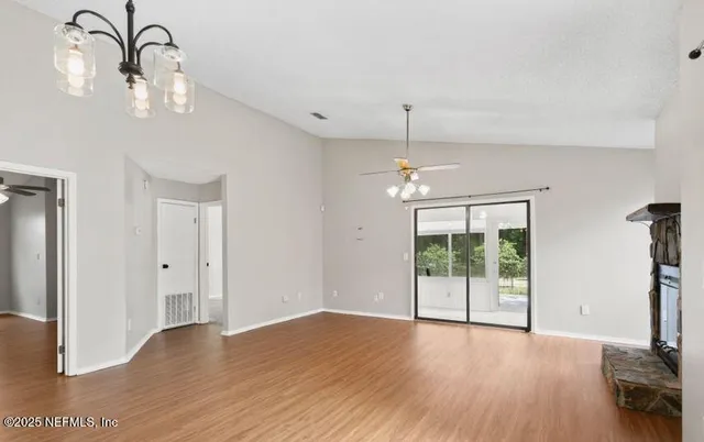 a view of a room with wooden floor chandelier and entryway