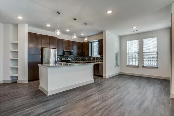 a view of kitchen with stainless steel appliances refrigerator oven stove microwave and cabinets