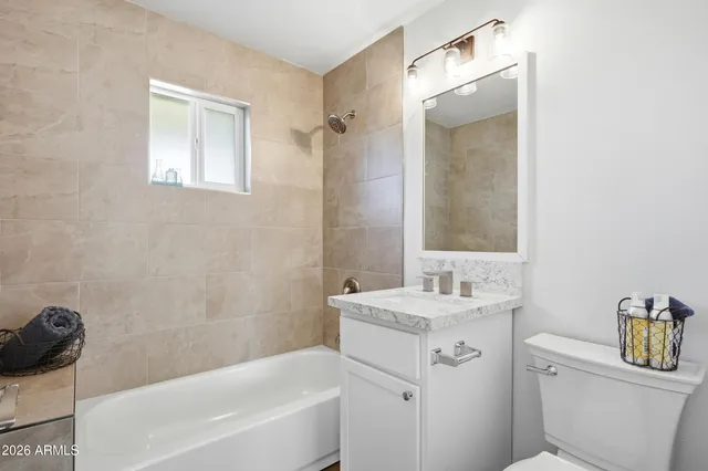 a bathroom with a sink toilet vanity and tub