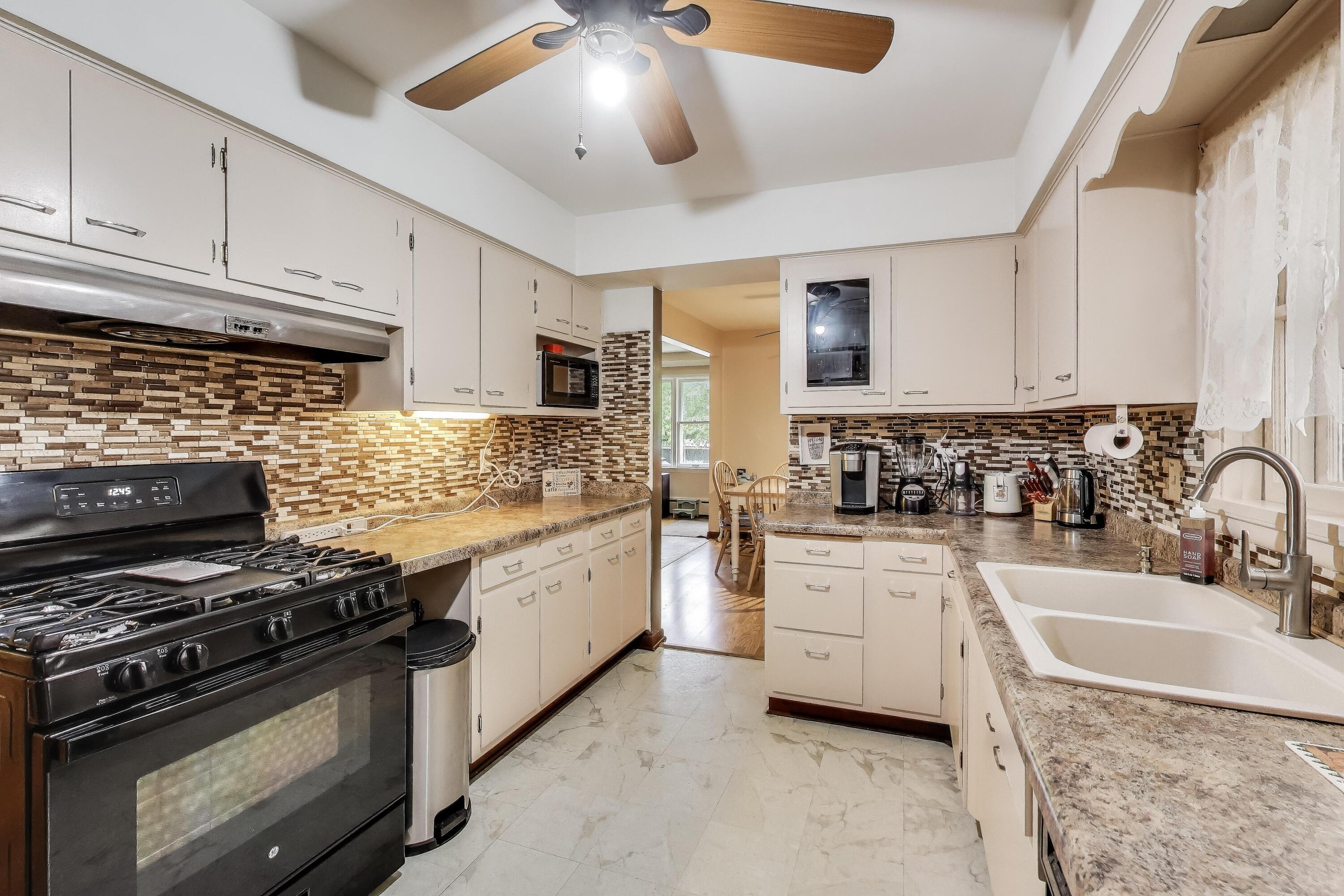 2036 Atchison Avenue Whiting, IN 46394 - Photo 8 of 30 a kitchen with stainless steel appliances granite countertop a sink stove and cabinets