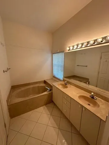 a bathroom with a tub sink and mirror
