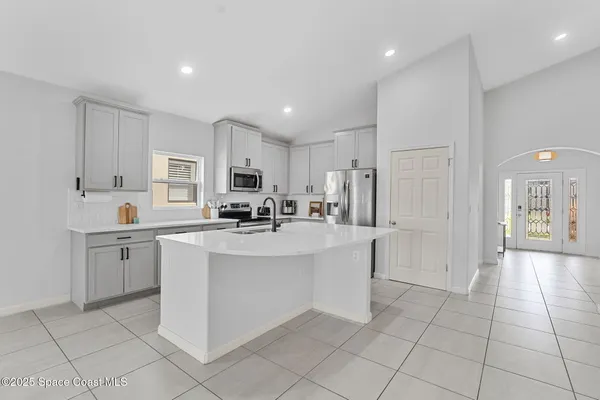 a kitchen with stainless steel appliances a refrigerator sink and microwave