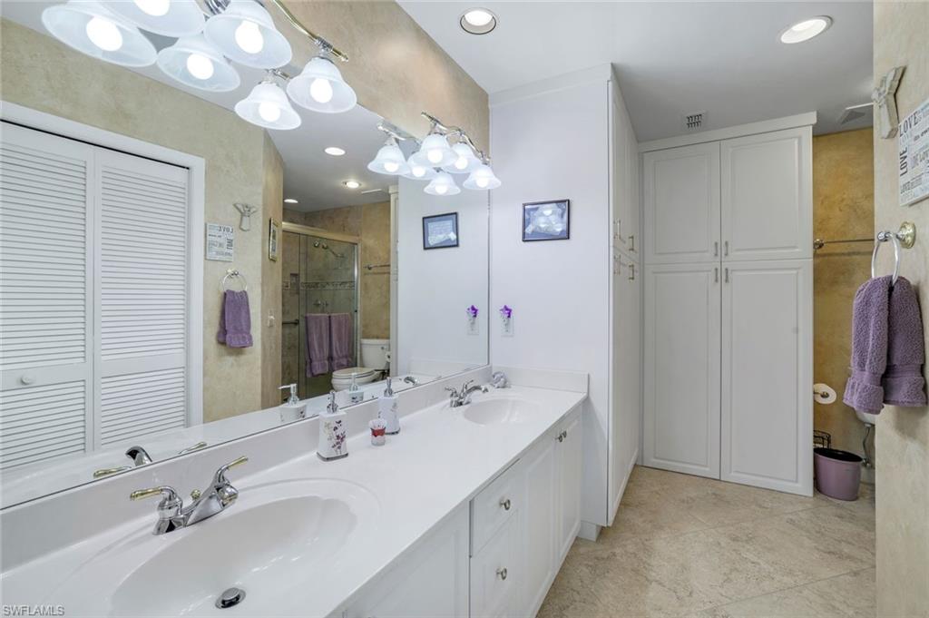914 Augusta Boulevard, Unit 7 Naples, FL 34113 - Photo 15 of 32 Bathroom with a closet, a sink, visible vents, and a stall shower