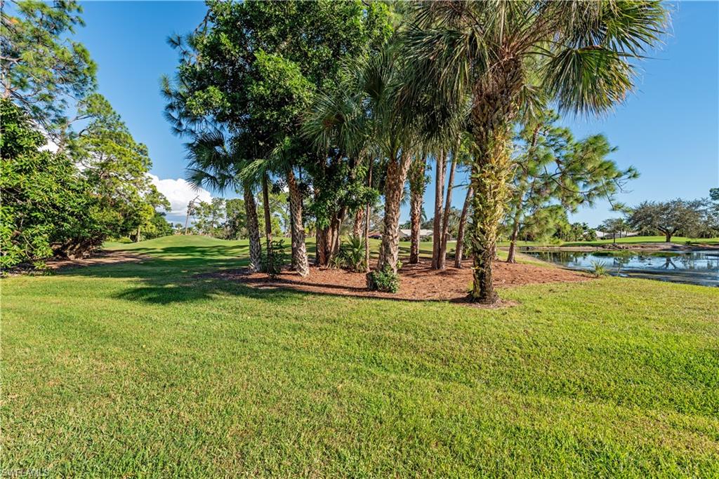 914 Augusta Boulevard, Unit 7 Naples, FL 34113 - Photo 25 of 32 View of grassy yard with a water view