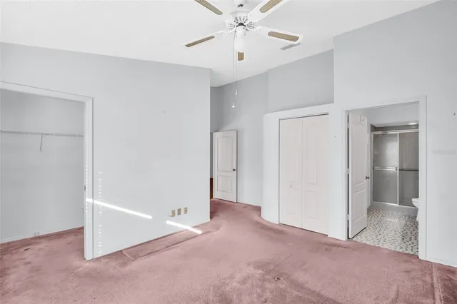 a view of an empty room with a chandelier fan