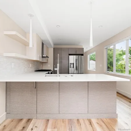 a kitchen with stainless steel appliances cabinets a large window and a sink