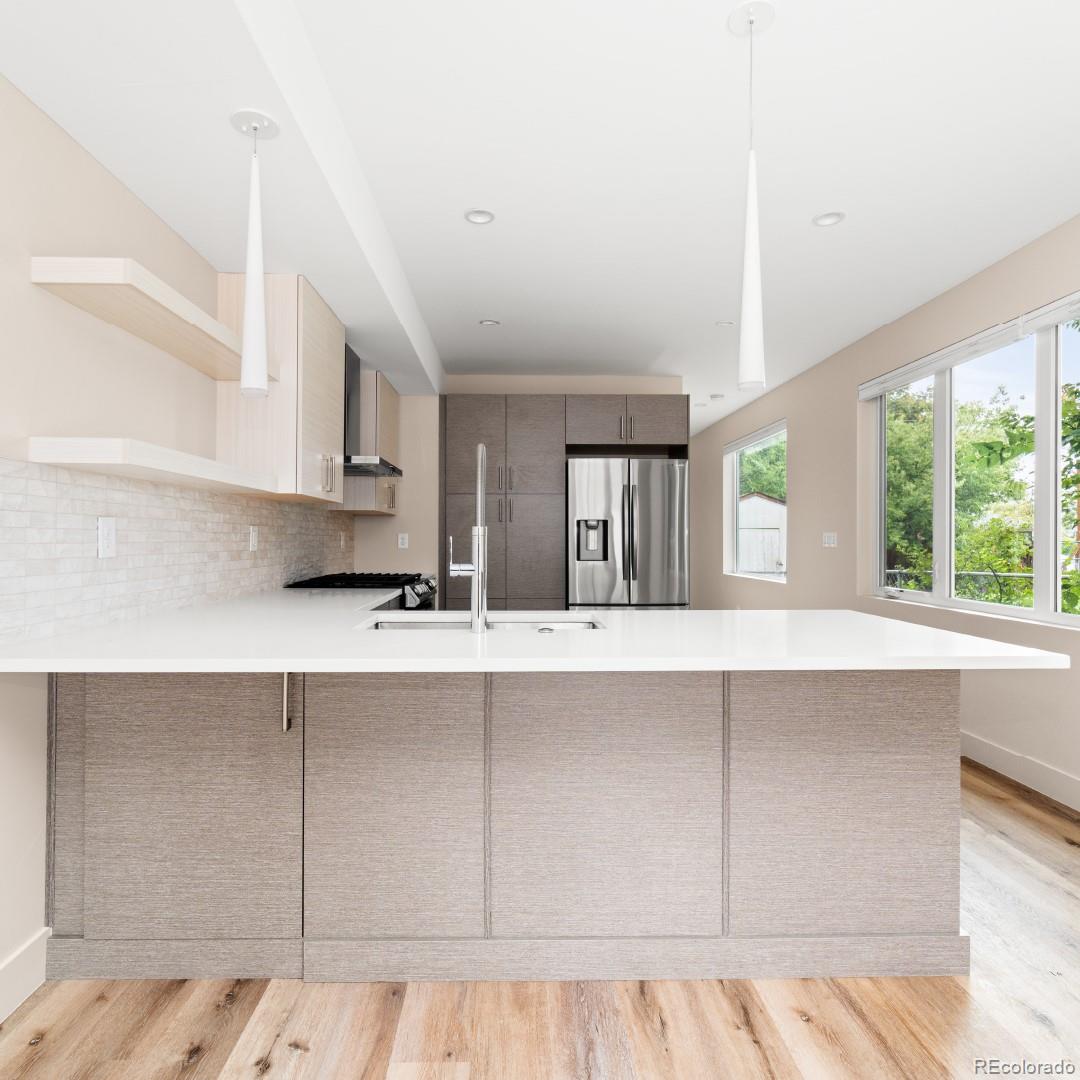 1318 Yates Street Denver, CO 80204 - Photo 4 of 14 a kitchen with stainless steel appliances cabinets a large window and a sink