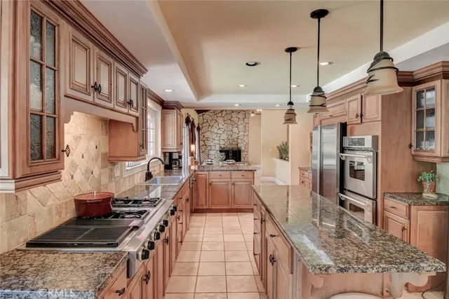 a kitchen with stainless steel appliances granite countertop a sink a stove and a wooden floors