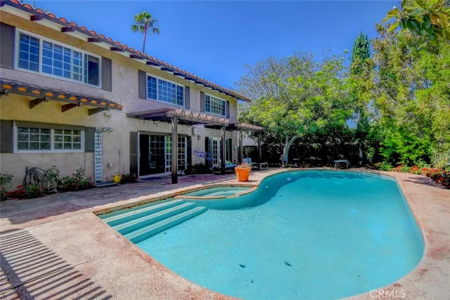 a front view of a house with swimming pool and furniture