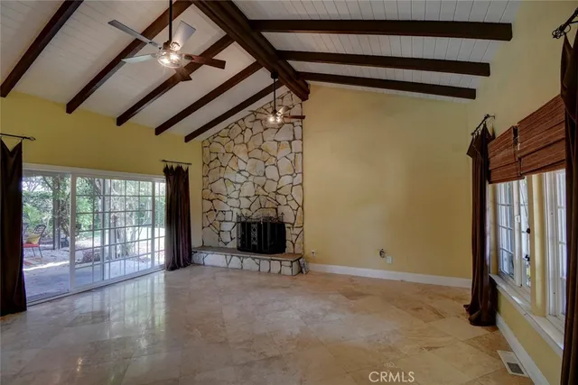 a view of an empty room with a fireplace and a window