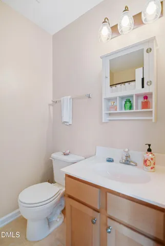 a bathroom with a sink vanity mirror and toilet