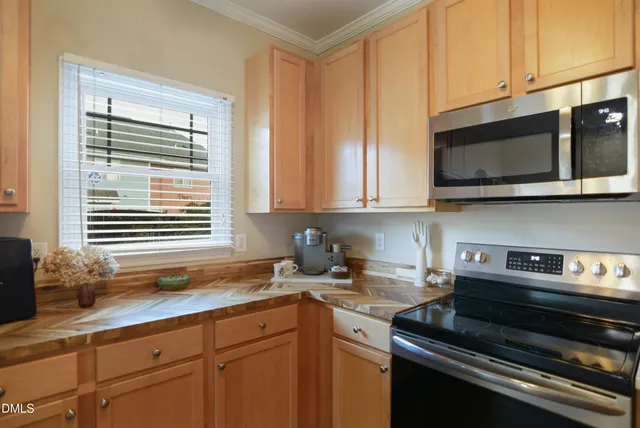 a kitchen with stainless steel appliances granite countertop white cabinets and a stove top oven