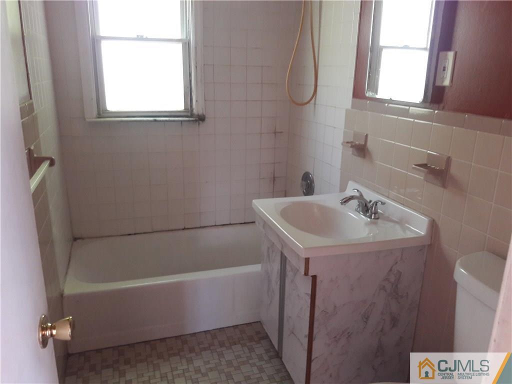 4 Sine Road Edison, NJ 08817 - Photo 11 of 25 a bathroom with a sink a bathtub and a window