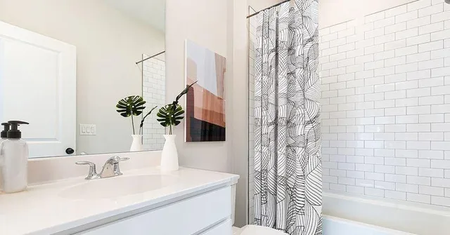 a bathroom with a sink a toilet a mirror and shower