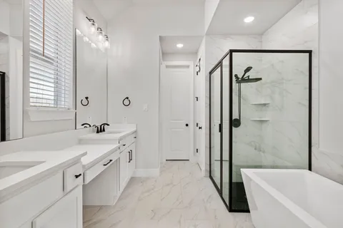 a bathroom with a tub sink shower and mirror