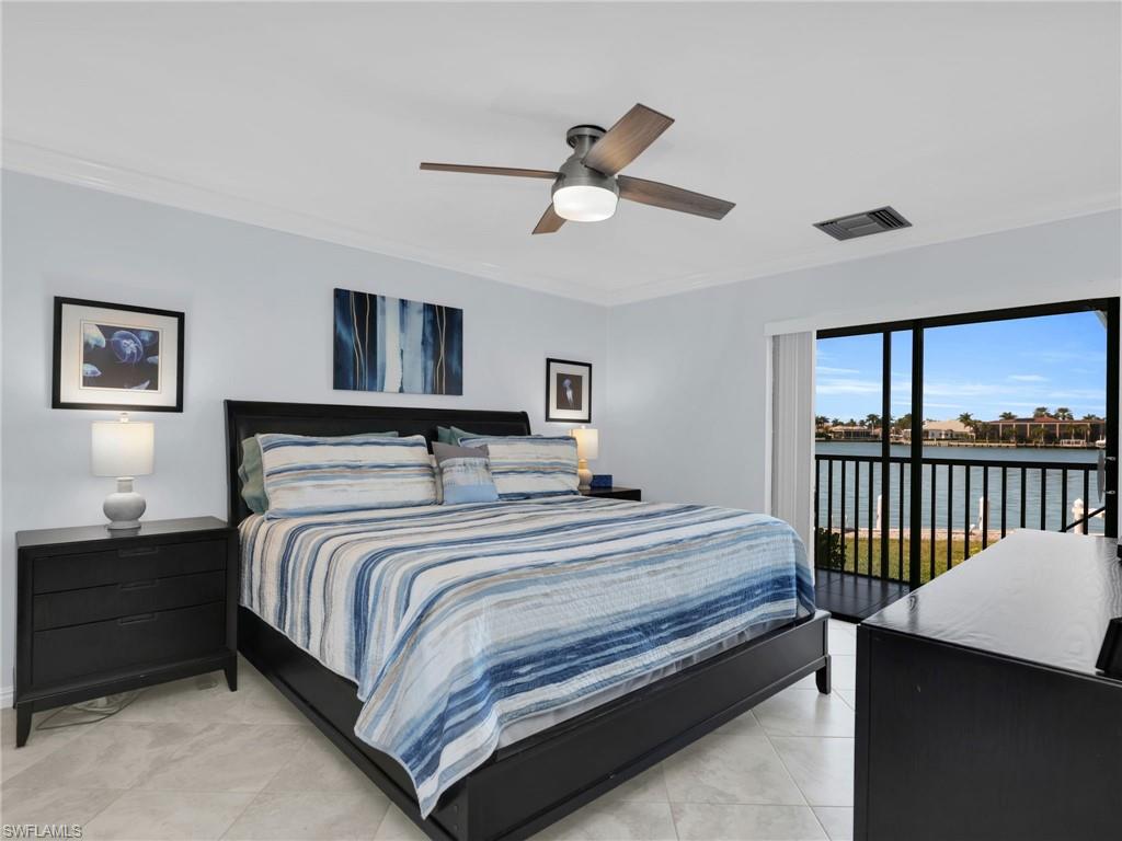 750 West Elkcam Circle, Unit 107 Marco Island, FL 34145 - Photo 11 of 33 Bedroom with crown molding, access to exterior, a water view, and ceiling fan