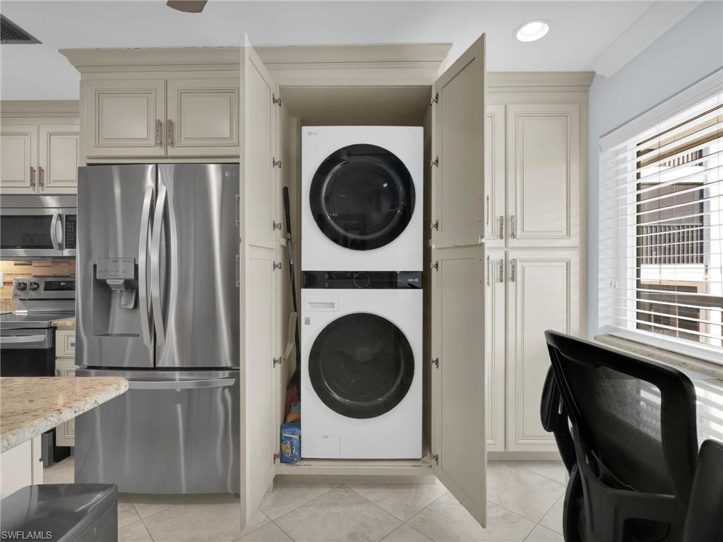 750 West Elkcam Circle, Unit 107 Marco Island, FL 34145 - Photo 15 of 33 Laundry area featuring stacked washer / dryer and light tile patterned flooring