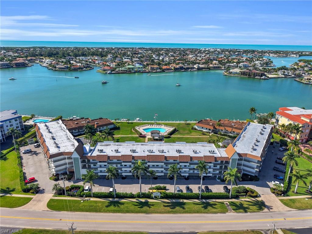 750 West Elkcam Circle, Unit 107 Marco Island, FL 34145 - Photo 19 of 33 Drone / aerial view of apartment complex / building and a nearby body of water