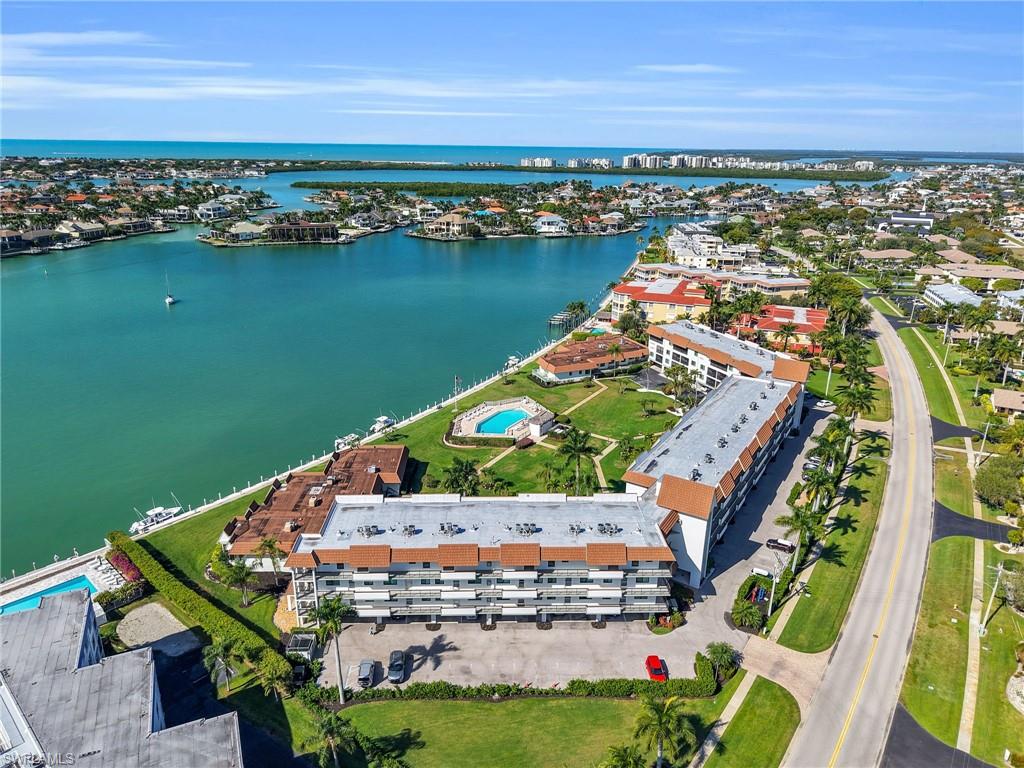 750 West Elkcam Circle, Unit 107 Marco Island, FL 34145 - Photo 20 of 33 Bird's eye view of a pool area and a nearby body of water