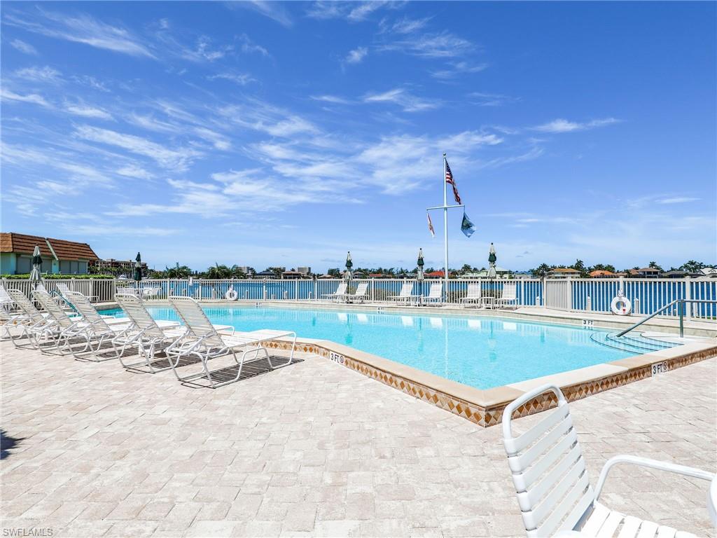 750 West Elkcam Circle, Unit 107 Marco Island, FL 34145 - Photo 21 of 33 Community pool featuring a patio