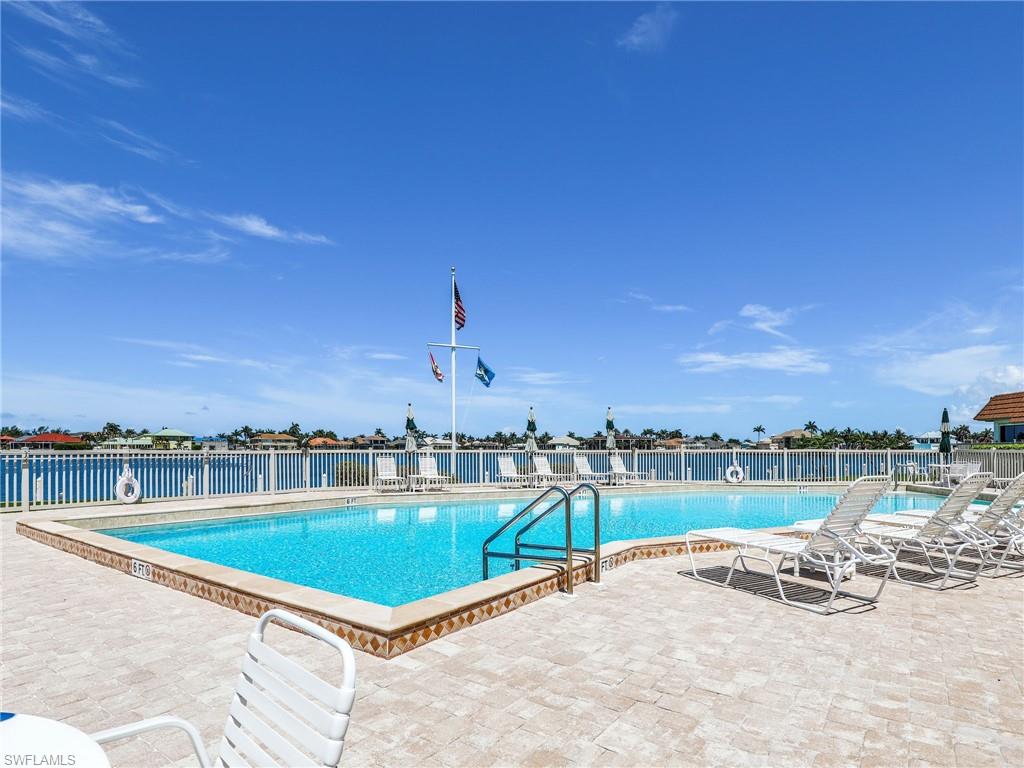 750 West Elkcam Circle, Unit 107 Marco Island, FL 34145 - Photo 22 of 33 Community pool featuring a patio