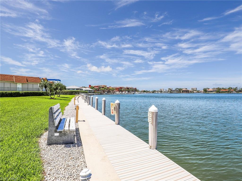 750 West Elkcam Circle, Unit 107 Marco Island, FL 34145 - Photo 23 of 33 Dock area featuring a water view and a lawn