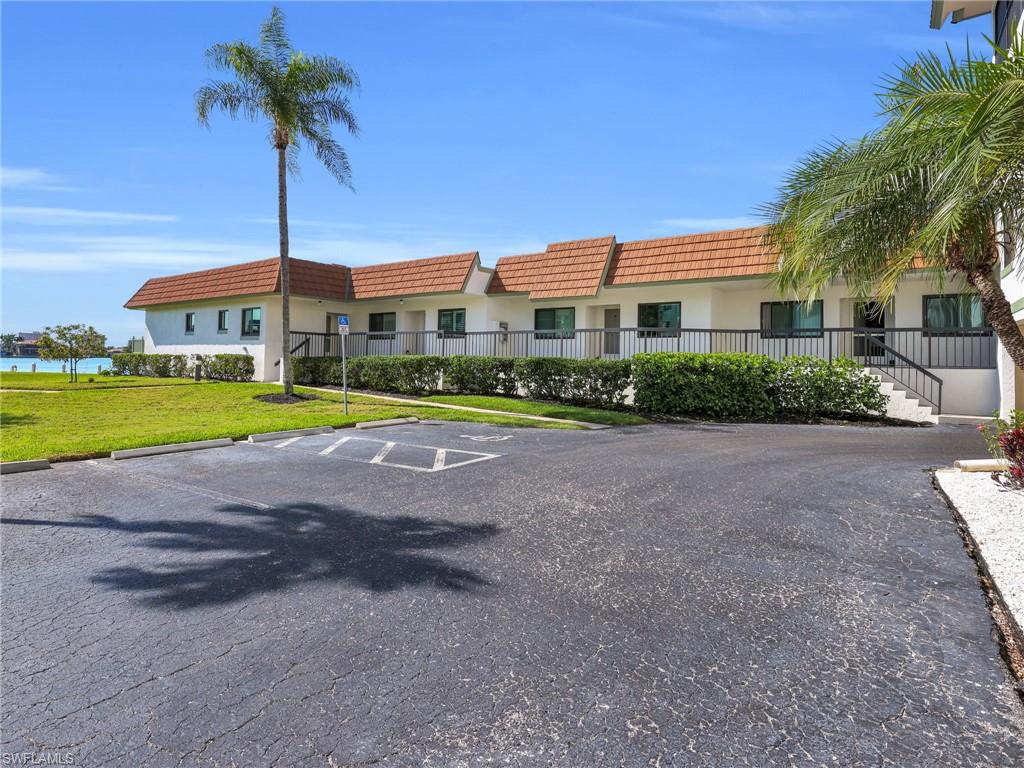 750 West Elkcam Circle, Unit 107 Marco Island, FL 34145 - Photo 25 of 33 View of building exterior with uncovered parking