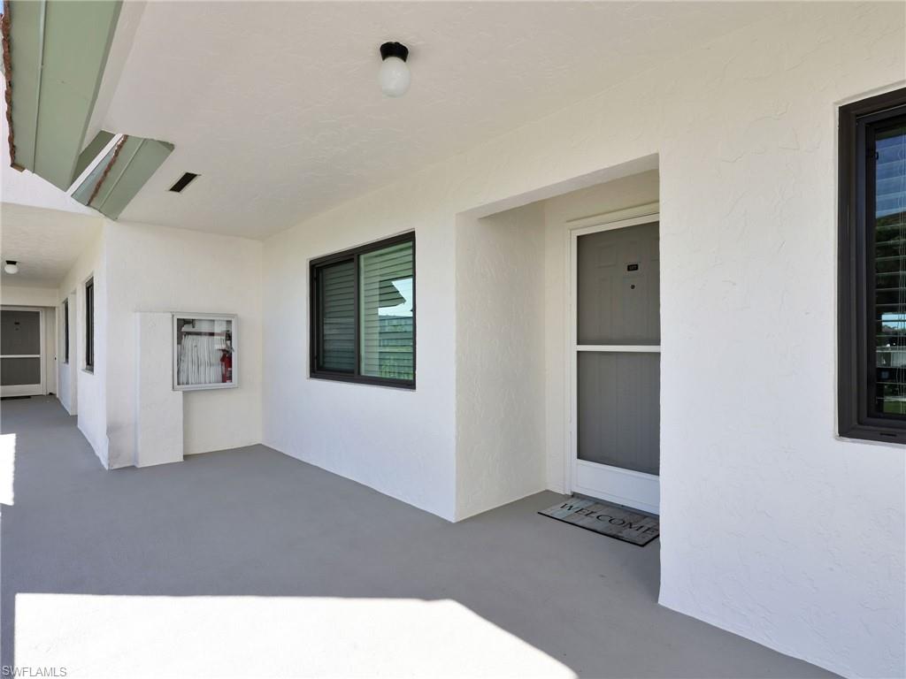750 West Elkcam Circle, Unit 107 Marco Island, FL 34145 - Photo 26 of 33 Doorway to property featuring stucco siding and a patio area