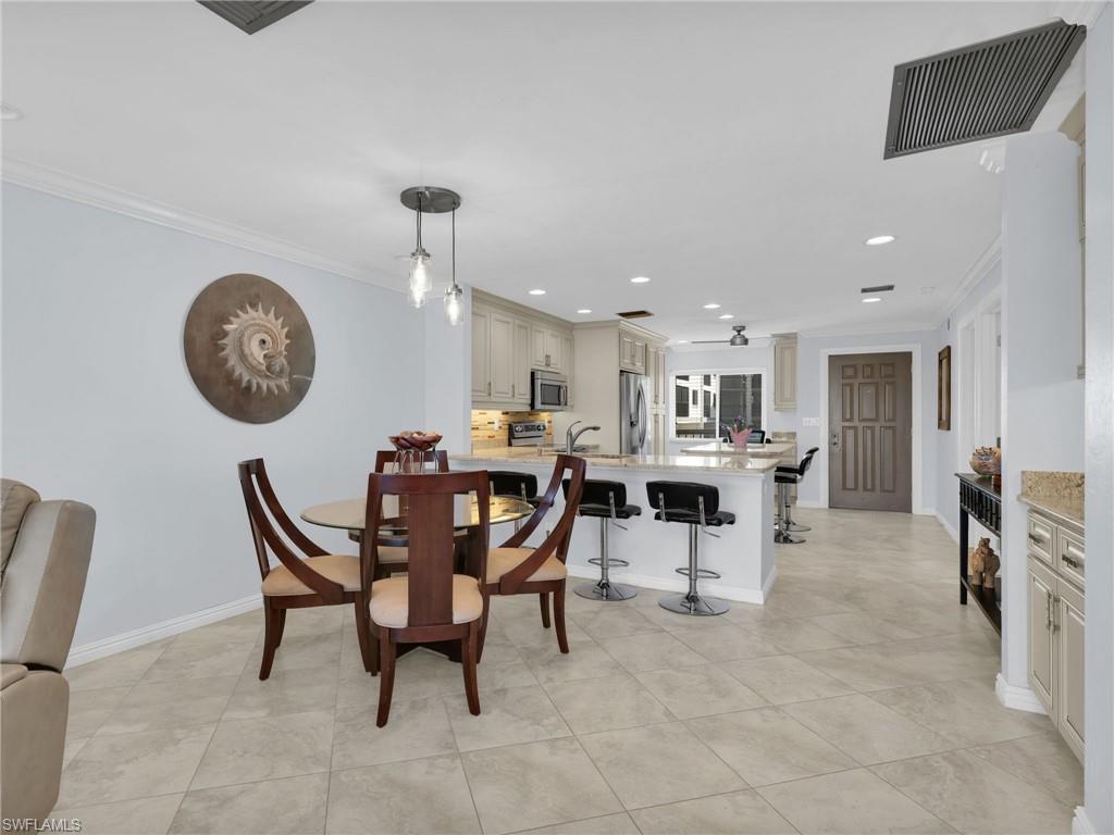 750 West Elkcam Circle, Unit 107 Marco Island, FL 34145 - Photo 6 of 33 Dining space with crown molding, recessed lighting, and light tile patterned flooring