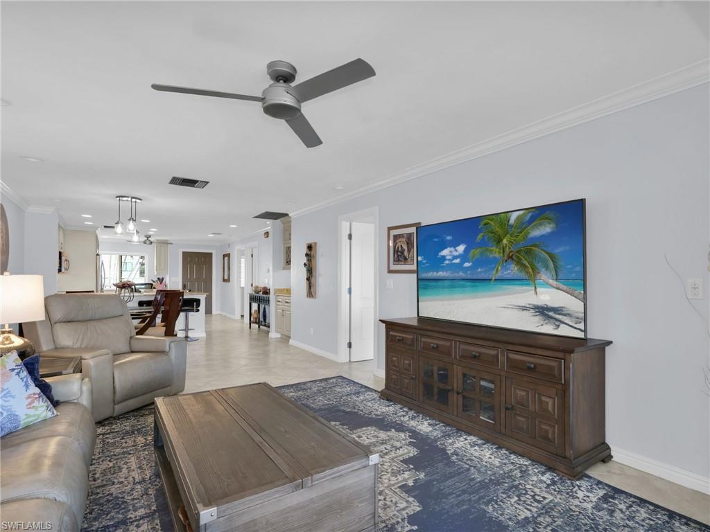 750 West Elkcam Circle, Unit 107 Marco Island, FL 34145 - Photo 8 of 33 Living room with crown molding and ceiling fan