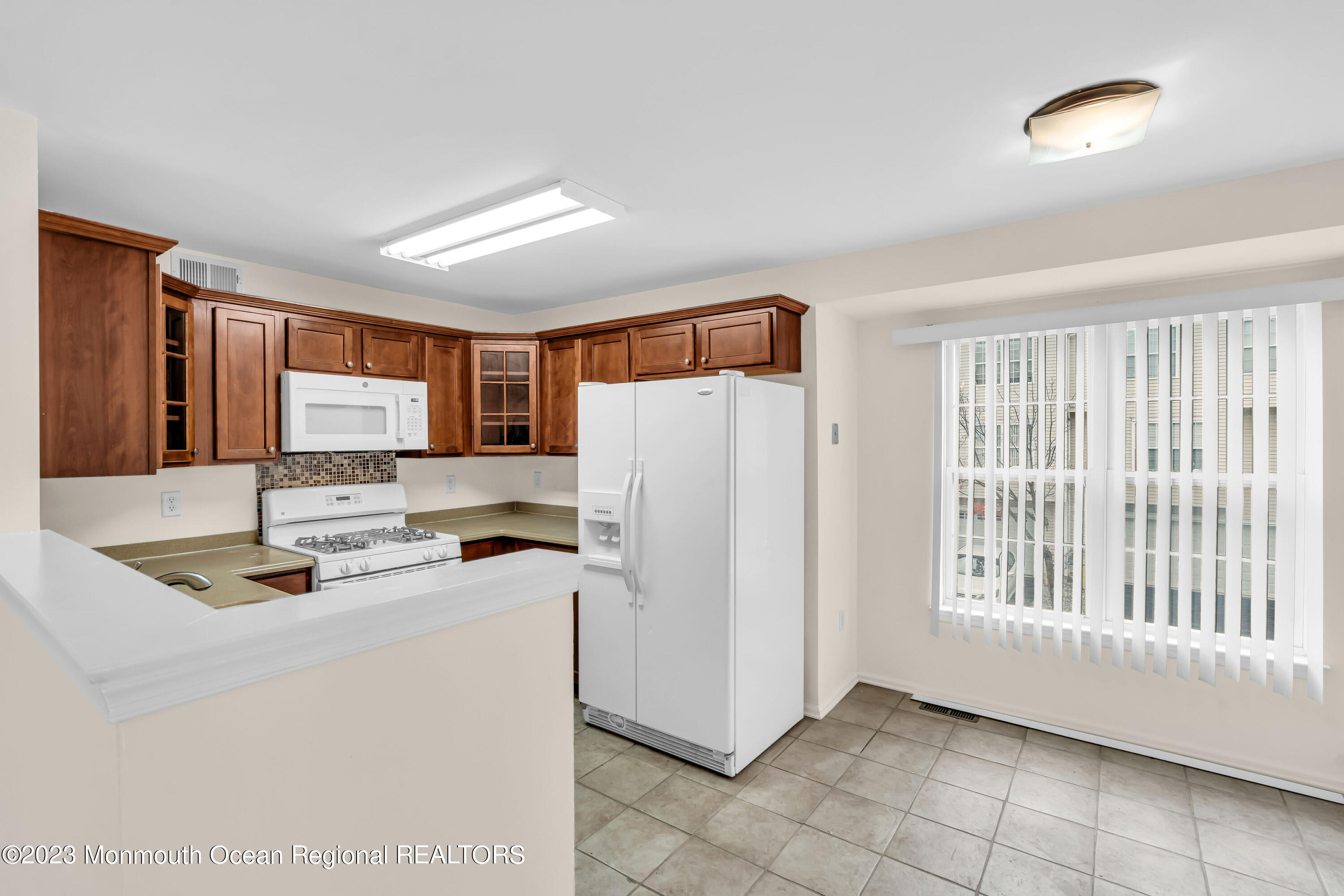 11 Kosmoski Terrace, Unit 106 Parlin, NJ 08859 - Photo 8 of 19 a kitchen with a refrigerator a stove top oven and a large window
