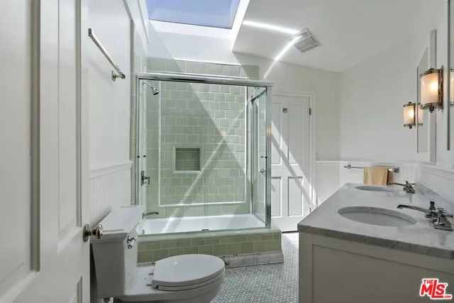 a bathroom with a granite countertop sink toilet and shower