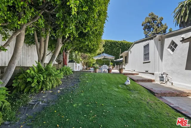 a view of a house with backyard and a sitting area