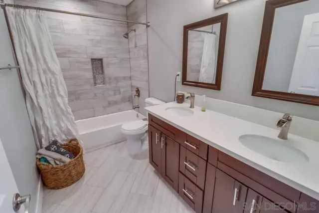 a bathroom with a double vanity sink toilet and shower