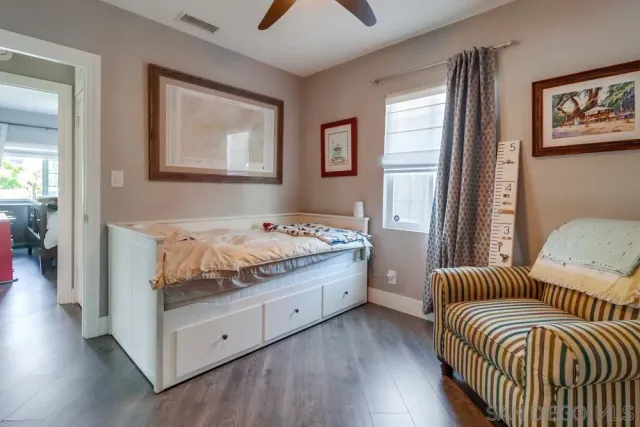 a room with a bed and a painting on the wall