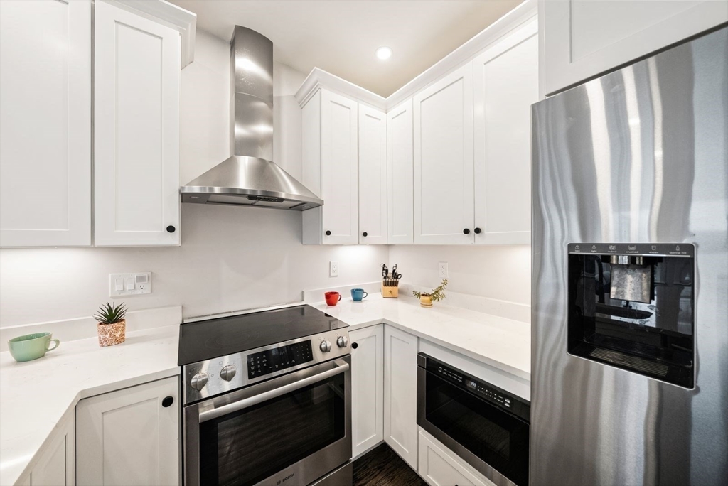 12-14 Porter Street, Unit 12 Boston, MA 02130 - Photo 8 of 37 a kitchen with stainless steel appliances a stove a sink and cabinets
