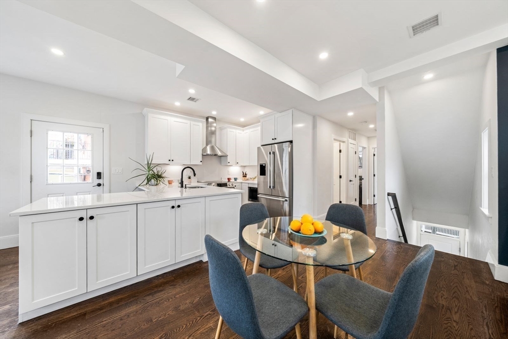 12-14 Porter Street, Unit 12 Boston, MA 02130 - Photo 10 of 37 a kitchen with stainless steel appliances granite countertop a dining table chairs and white cabinets