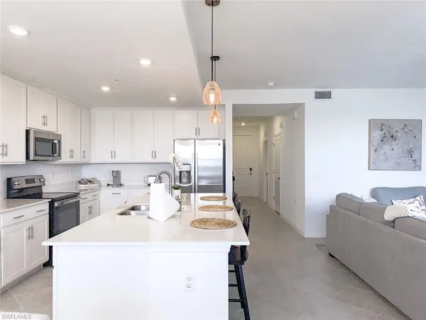 a kitchen with a sink a stove and chairs